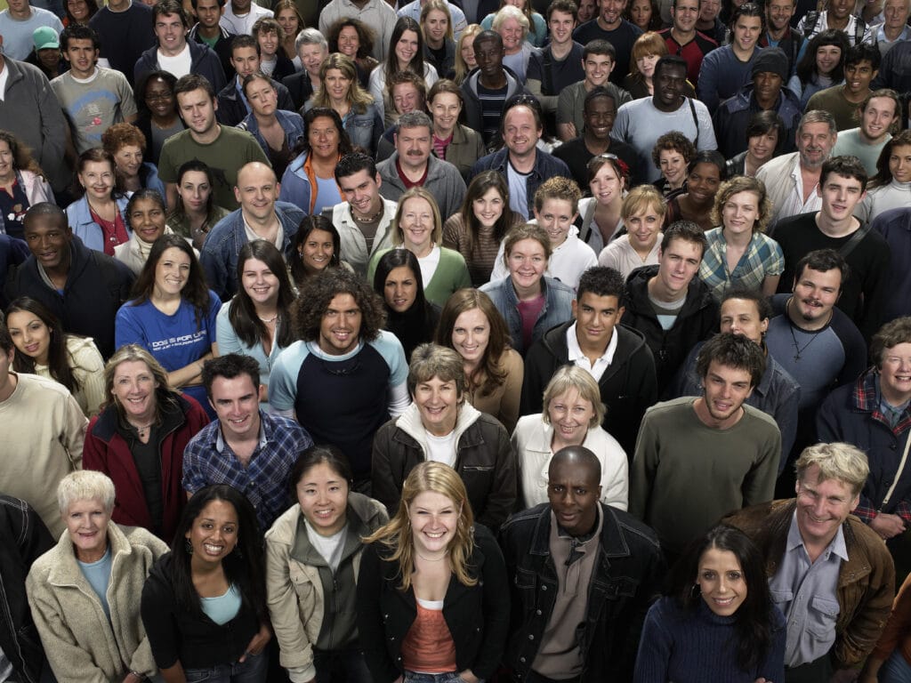 Large crowd of people of diverse backgrounds looking up, smiling, portrait, elevated view