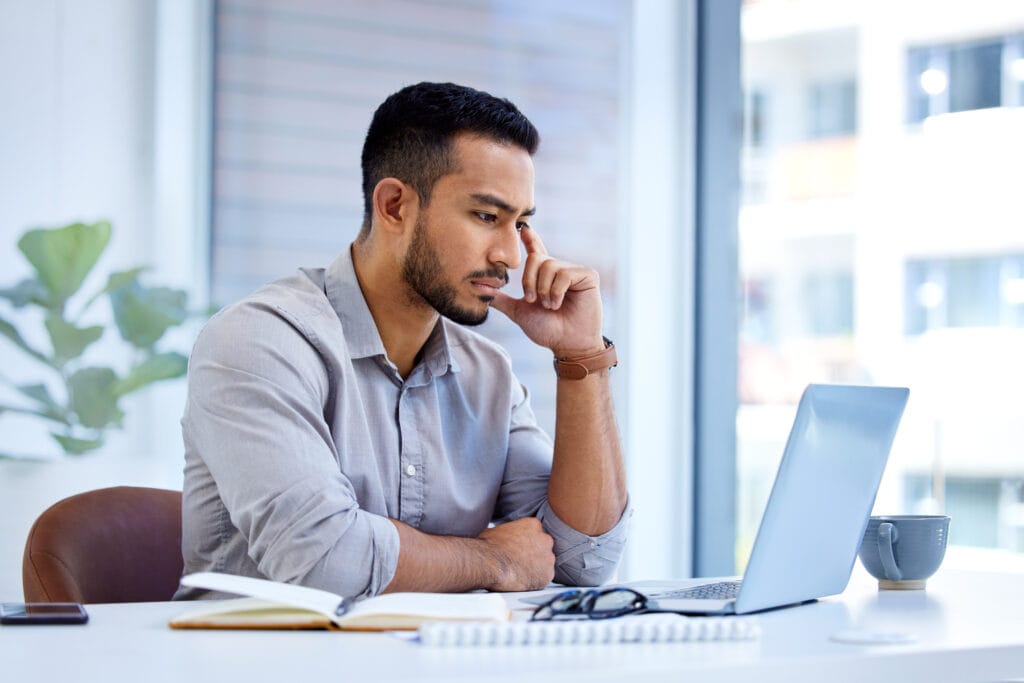 Shot of a young businessman working on a laptop in an office